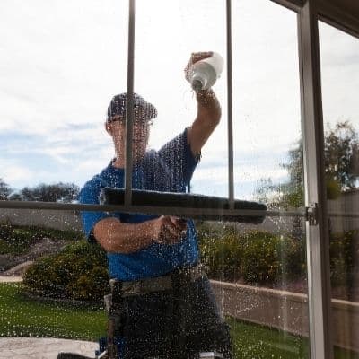 a picture of a man cleaning a window
